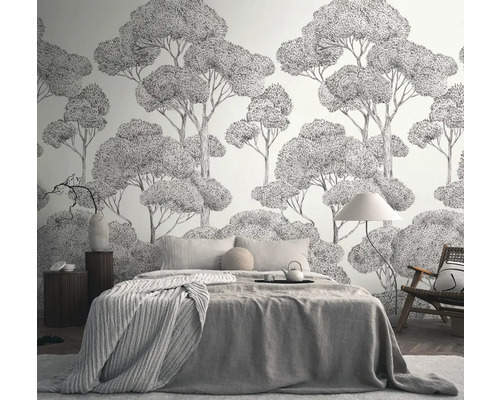 Slaapkamer met behang met boommotief, bed, stoel en nachtkastje