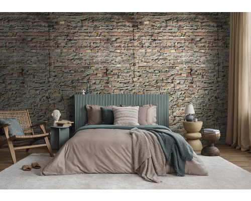 Een slaapkamer met bakstenen muur, bed, stoel en bijzettafels voor een gezellige sfeer.