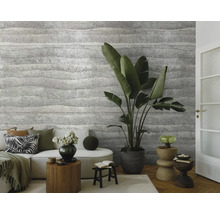 Woonkamer met bank, kamerplanten en een muur met gestructureerd behang