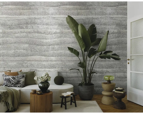 Woonkamer met bank, kamerplanten en een muur met gestructureerd behang