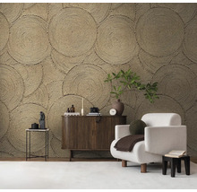 Woonkamer met decoratief cirkelwandbehang, fauteuil en houten dressoir.