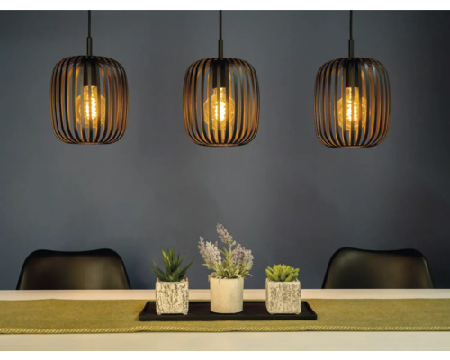 Scene met drie hanglampen boven een tafel met decoratie en stoelen.