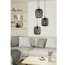 Scene met drie zwarte hanglampen boven een bank in een lichte woonkamer