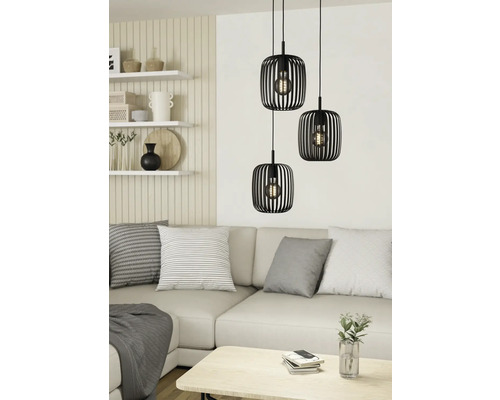 Scene met drie zwarte hanglampen boven een bank in een lichte woonkamer