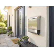 Roestvrijstalen brievenbus aan een huismuur naast een voordeur