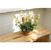 Decoratief bloemstuk met narcissen in keramische pot op houten tafel