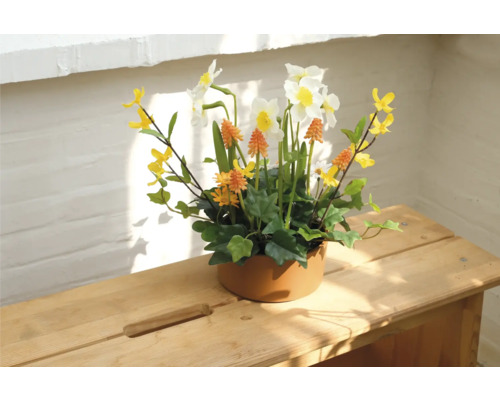 Decoratief bloemstuk met narcissen in keramische pot op houten tafel