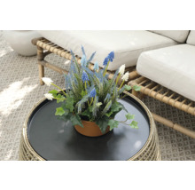 Decoratieve kunstbloemen in een pot op een rotantafel