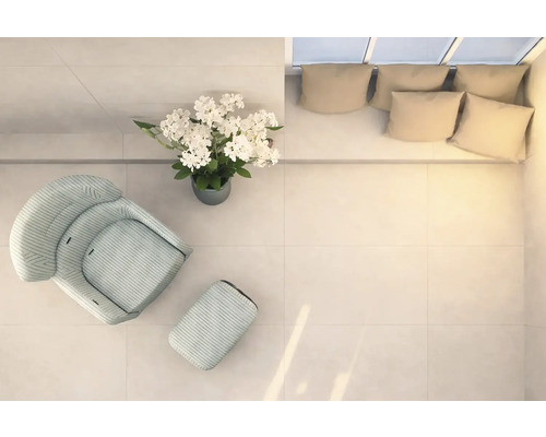 Lichte ruimte met fauteuil, voetenbank, bloemstuk en bank met kussens, van bovenaf genomen