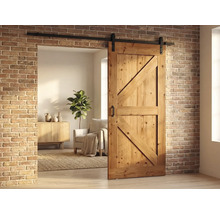 Houten schuifdeur in schuurstijl met zwarte rail tegen een bakstenen muur