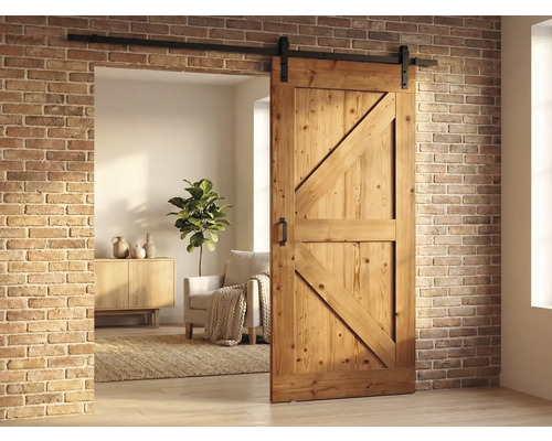 Houten schuifdeur in schuurstijl met zwarte rail tegen een bakstenen muur