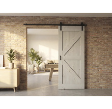 Houten schuifdeur voor een bakstenen muur met uitzicht op een lichte woonkamer