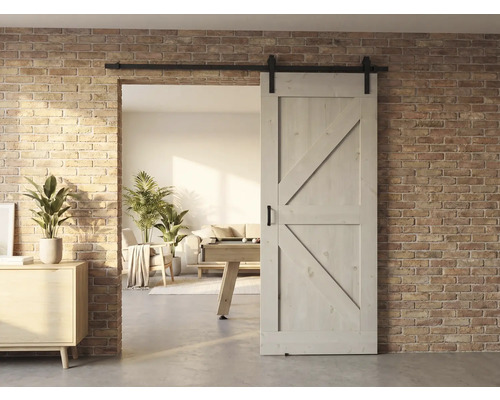 Houten schuifdeur voor een bakstenen muur met uitzicht op een lichte woonkamer