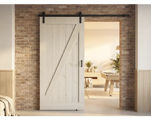 Houten schuifdeur in landhuisstijl met beslag voor een bakstenen muur