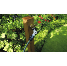 Tuinscene met kraan, tuinslang en koppeling