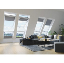 Woonkamer met dakramen en grijze rolgordijnen voor dakramen.