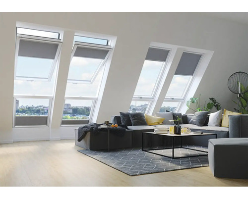 Woonkamer met dakramen en grijze rolgordijnen voor dakramen.