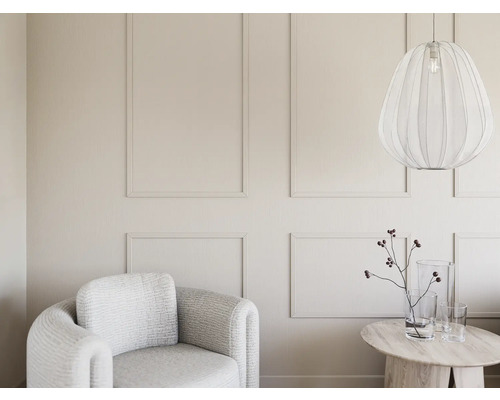 Lichte woonkamer met fauteuil, tafel en hanglamp