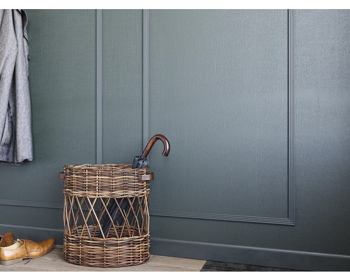 Hal met wandpanelen, paraplubak van vlechtwerk en een paraplu