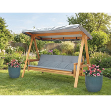 Houten schommelbank met grijze kussens en afdak in de tuin