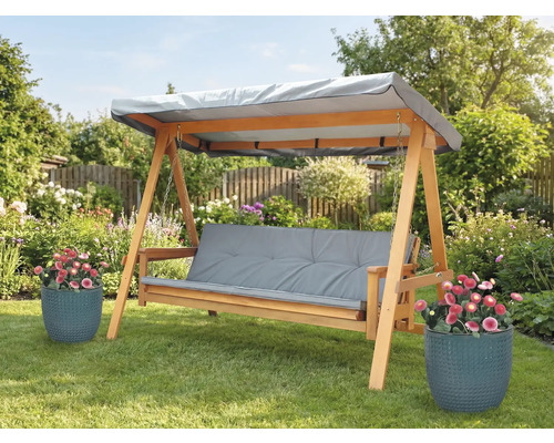 Houten schommelbank met grijze kussens en afdak in de tuin
