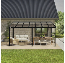 Vrijstaande terrasoverkapping met meubels op een houten terras voor een huis.
