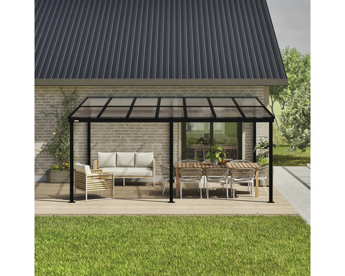 Vrijstaande terrasoverkapping met meubels op een houten terras voor een huis.