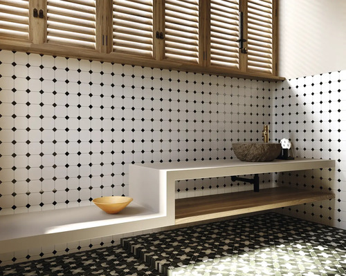 Badkamer met witte tegelwand met zwart stippenpatroon, wastafel met stenen wasbak en houten plank