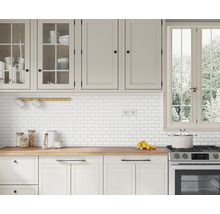 Lichte keuken met witte kasten, houten werkblad en witte tegels
