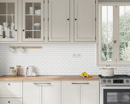 Lichte keuken met witte kasten, houten werkblad en witte tegels