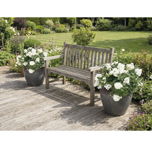 Tuinscene met houten bank en bloempotten op een houten terras