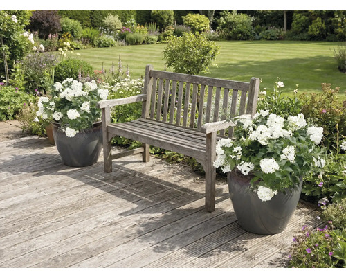 Tuinscene met houten bank en bloempotten op een houten terras
