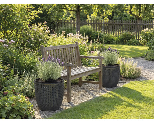 Tuinlandschap met houten bank en planten in gestructureerde plantenbakken