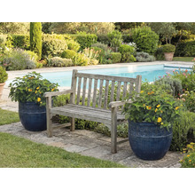 Tuin scène met houten bank en bloempotten naast een zwembad