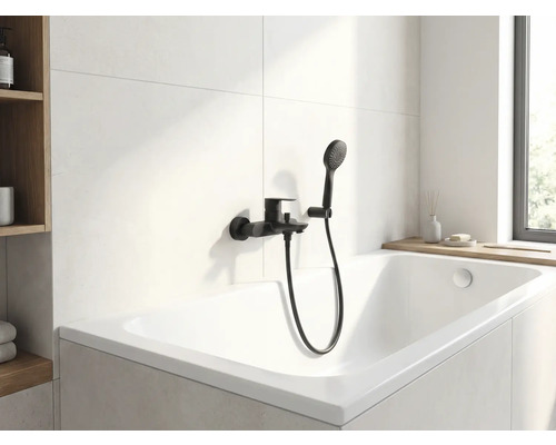 Moderne badkamer met wit ligbad en zwarte kraan met handdouche.