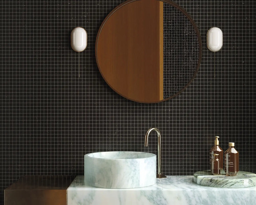 Moderne badkamer met donkere tegels, ronde spiegel en marmeren wastafel