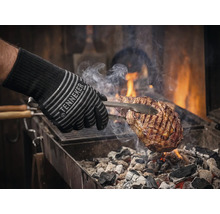 Barbecuehandschoen met vlees op de grill