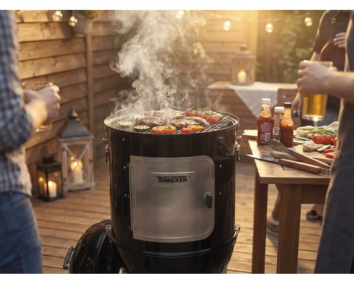 Rookgrill met vlees en groenten op het grillrooster tijdens een barbecue in de tuin.