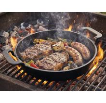 Grillpan met steaks, worstjes en groenten op de barbecue