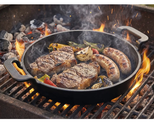 Grillpan met steaks, worstjes en groenten op de barbecue