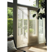 Interieurbeeld met paneelgordijn voor een terrasdeur, dat het daglicht zacht filtert