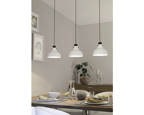 Eettafelscène met drie witte hanglampen boven de tafel