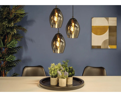 Eetkamer met drie hanglampen, tafel, decoratie en twee stoelen