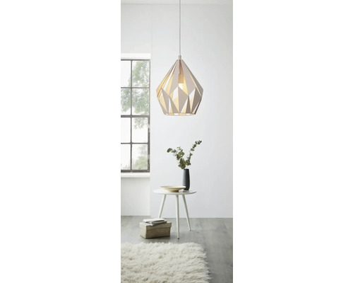 Moderne hanglamp met geometrisch design boven een tafel met decoratie in een lichte ruimte.