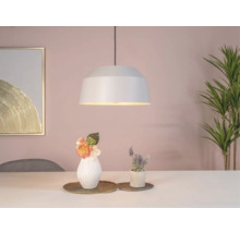 Hanglamp boven een tafel met decoratie en kamerplant