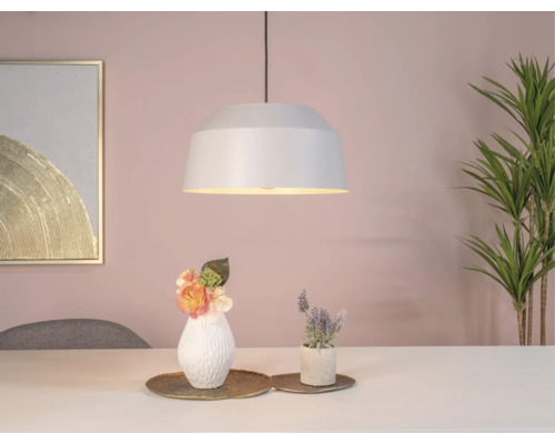 Hanglamp boven een tafel met decoratie en kamerplant