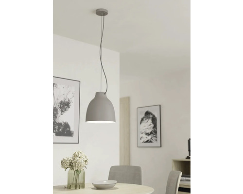 Grijze metalen hanglamp boven een eettafel