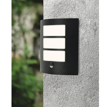 Zwarte wandlamp met bewegingsmelder en drie rechthoekige lichtvensters aan een muur.