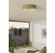 Beige plafondlamp met zichtbare gloeilamp in de woonkamer.