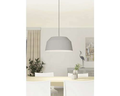 Grijze hanglamp boven een eettafel met witte stoelen